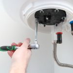 plumber flushing the water heater