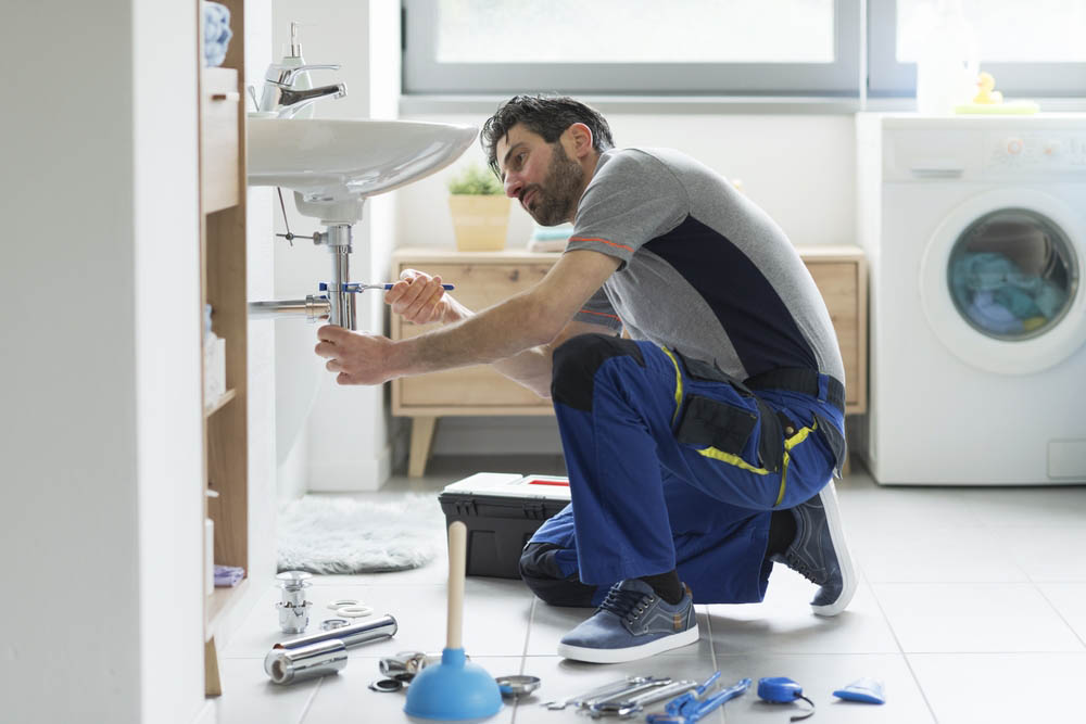 plumber repairing a leaky pipe Columbia, MO